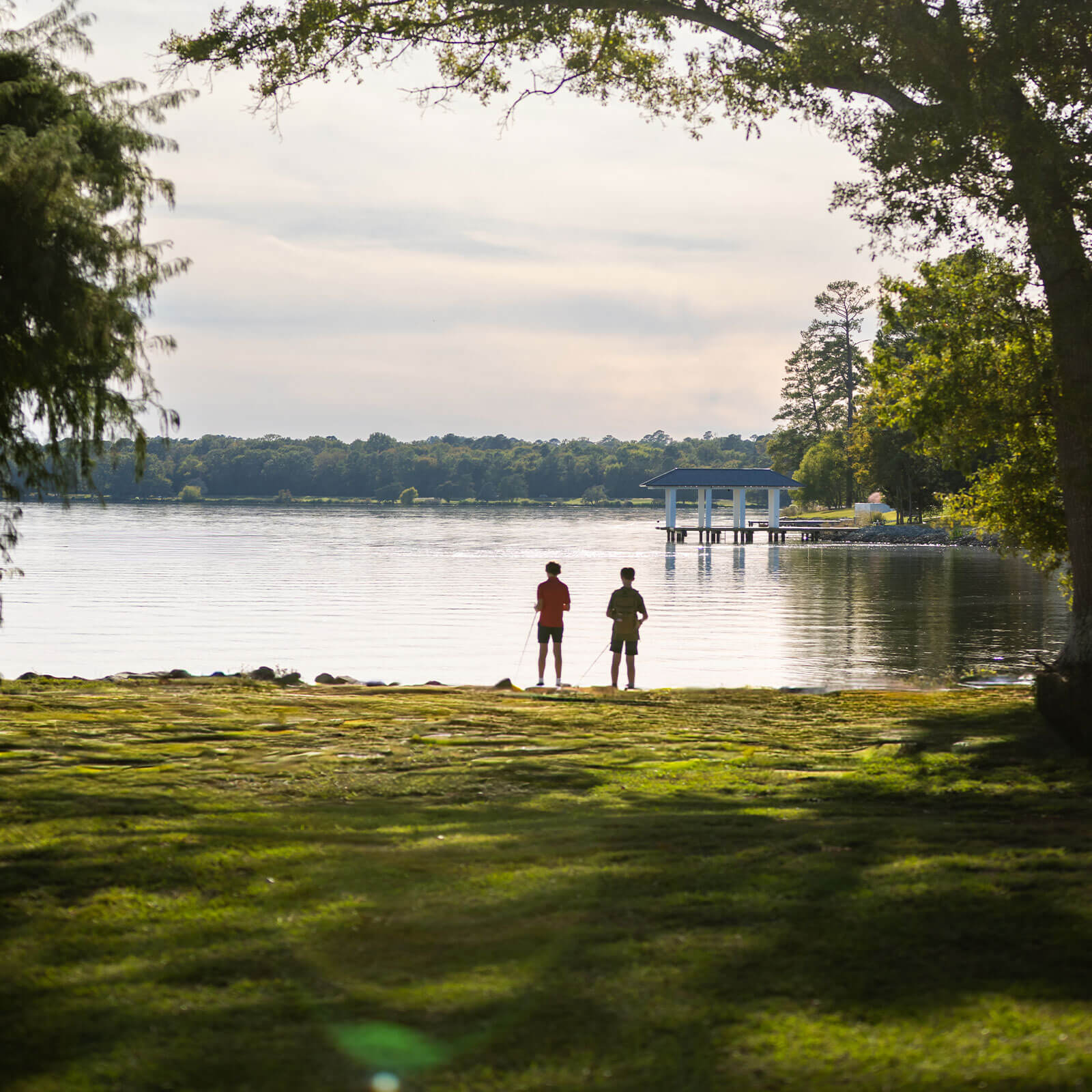 Two boys fish from the bank near a private pier on the shore of Ross Barnett Reservoir.