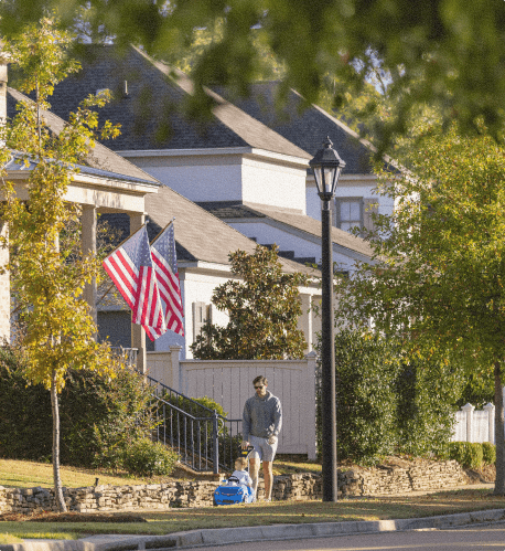 A parent and child strolling on a sidewalk in The Town of Lost Rabbit.