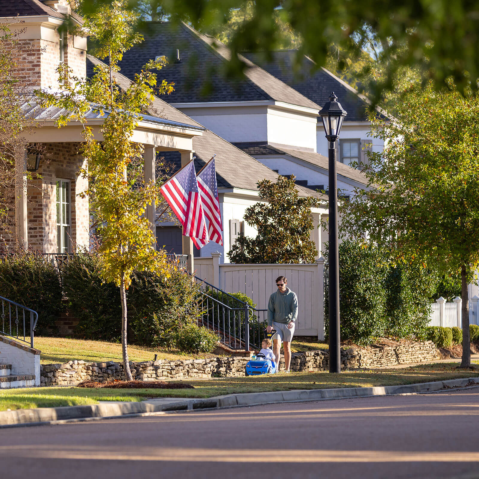A parent and child strolling on a sidewalk in The Town of Lost Rabbit.