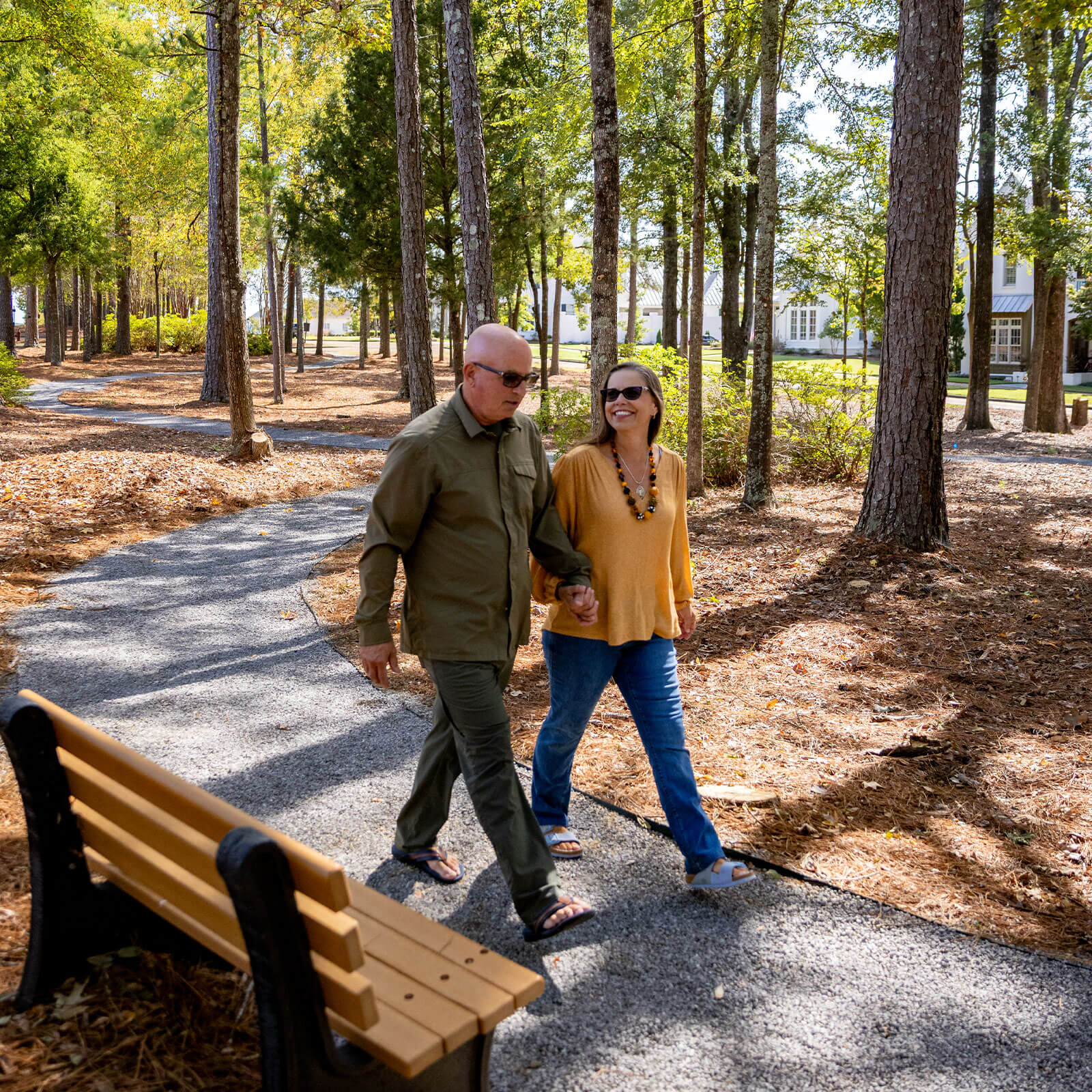 A man and woman stroll on a path in the woods near the Lost Rabbit neighborhood.