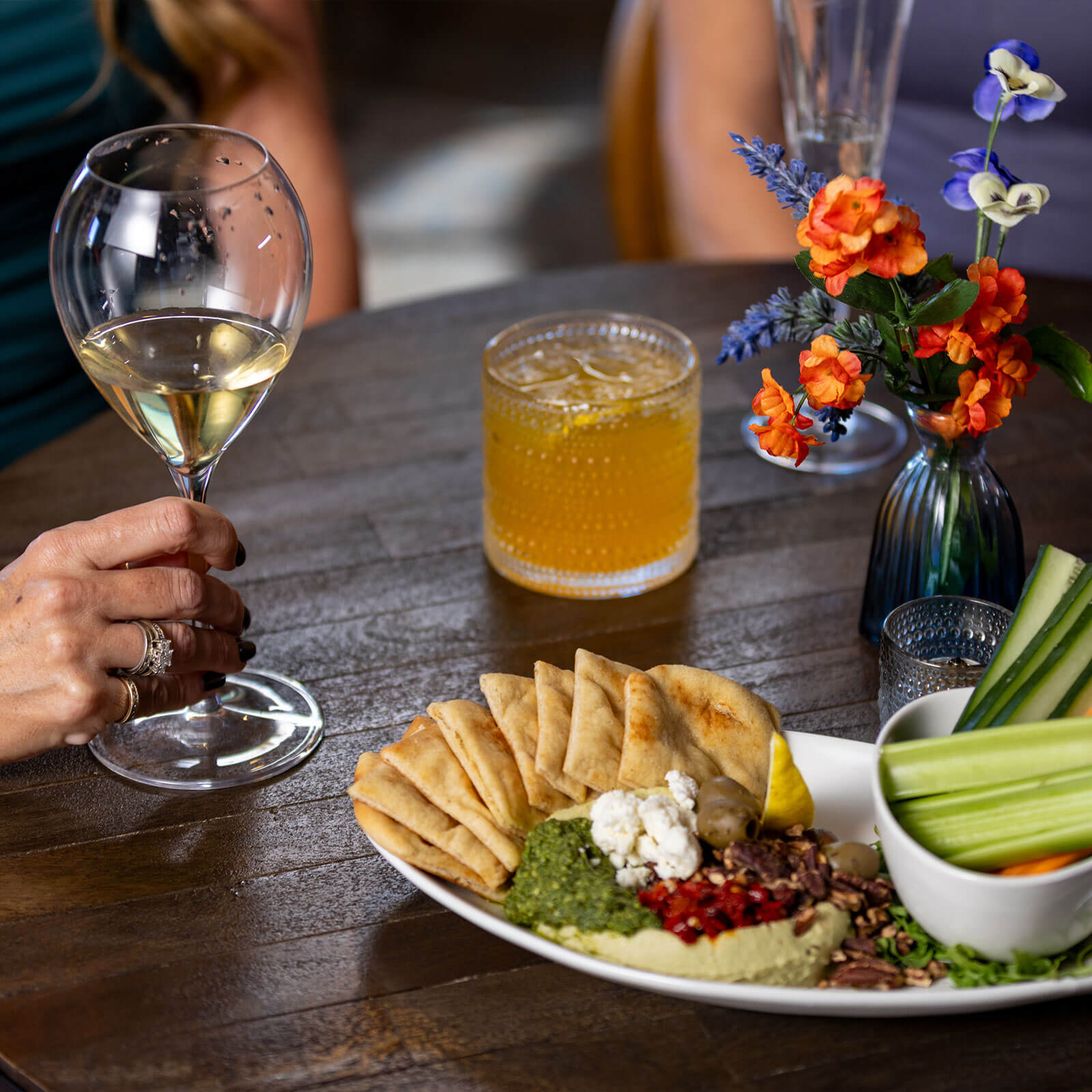 A cocktail and plate of snacks sit on a table at The Rabbit Hole.